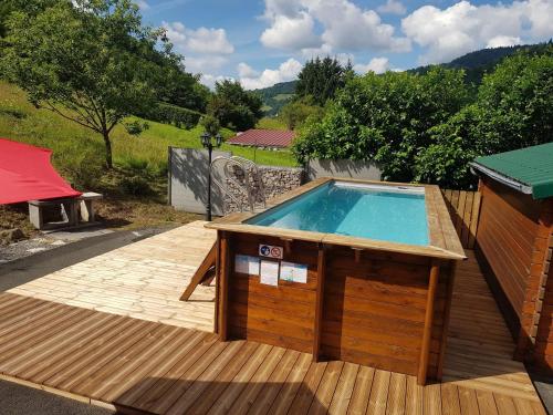 - une piscine sur une terrasse avec une maison dans l'établissement Chalet chaleureux à Cornimont avec piscine privée, à Cornimont