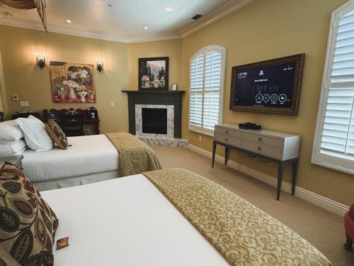 a bedroom with two beds and a flat screen tv at Villa Arden Hills in Sacramento