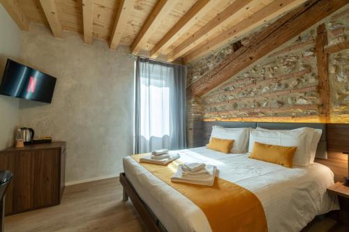 Un dormitorio con una cama grande con una pared de piedra. en La Casa in Paese, en Peschiera del Garda
