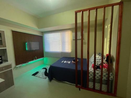 a bedroom with a bed in a room with a gate at Cozy City Escape - Avida Aspira Tower 1, CDO in Cagayan de Oro