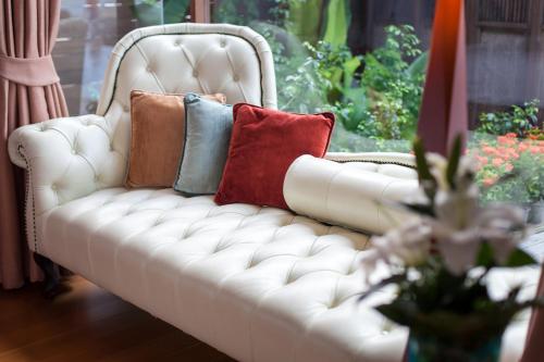 a white couch with pillows on it in a living room at Tango Luxe Beach Villa, Koh Samui in Choeng Mon Beach