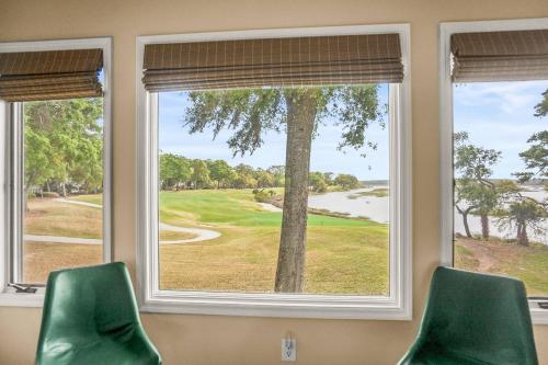 two green chairs sitting in front of a window at Dataw Island 2004 Bluff Villa in Ashdale