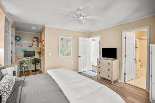 a bedroom with a bed and a television and a desk at Dataw Island 2004 Bluff Villa in Ashdale
