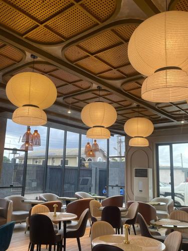 a dining room with tables and chairs and chandeliers at Vertus Hotel and Suites in Benin City