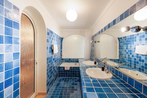 - une salle de bains carrelée de bleu avec deux lavabos et un miroir dans l'établissement Una Rosa Blu YourHostHelper, à Cannes