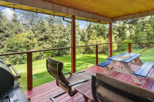 a porch with a picnic table and chairs on it at The Four Pines Near to Red Rocks And Morrison in Morrison