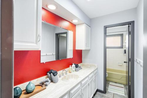 a bathroom with two sinks and a red wall at The Four Pines Near to Red Rocks And Morrison in Morrison