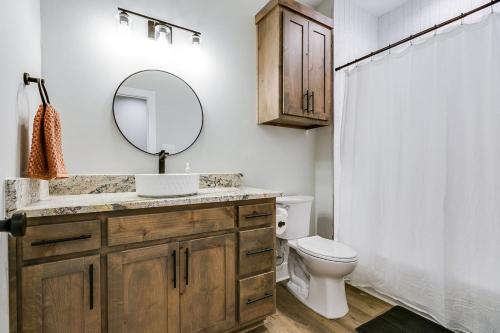 a bathroom with a sink and a mirror and a toilet at The Inn at Holiday 3BR 2 and a half BA in San Angelo