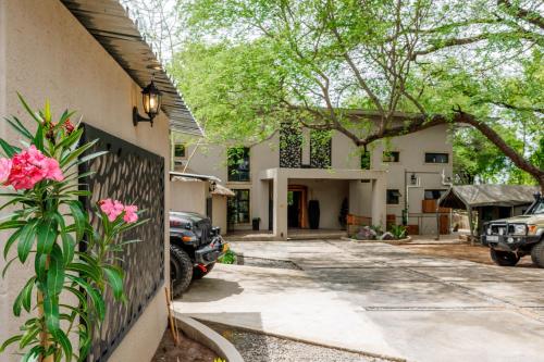 a house with a car parked in front of it at Chobe House Villa and Chalets in Kasane
