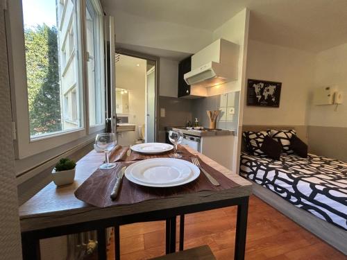 - une table avec deux assiettes et des verres à vin dans l'établissement Studio 96 - Wi fi fibre - Résidence Beauséjour - Proche centre ville, à Troyes