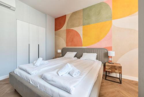 a bedroom with a large bed with a colorful wall at Retro Boutique by NorthSide Apartments in Gdańsk