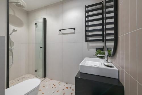 a bathroom with a sink and a toilet and a mirror at Retro Boutique by NorthSide Apartments in Gdańsk