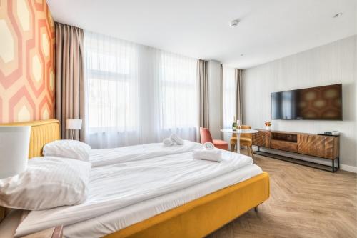 a hotel room with a large bed and a television at Retro Boutique by NorthSide Apartments in Gdańsk