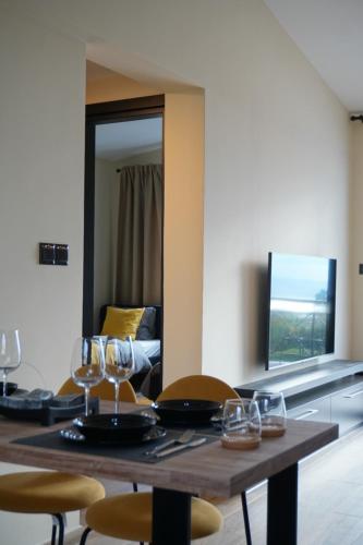 a dining room table with wine glasses and a couch at Wonderful view from the beautiful apartments in Paphos City