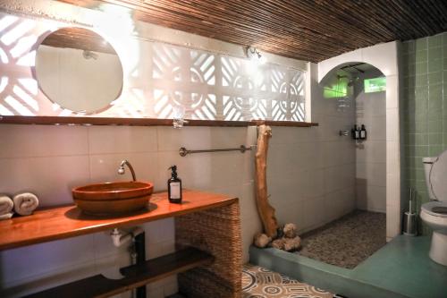 a bathroom with a sink and a toilet and a mirror at Casa Marimba in La Laguna