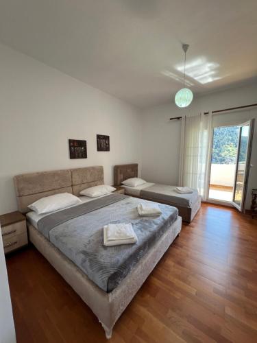 Un dormitorio con dos camas y una gran ventana. en EK-Center Vila Berat, en Berat