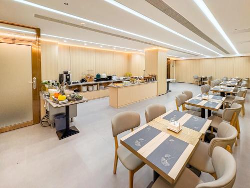 a restaurant with tables and chairs and a kitchen at Yibo Hotel - Pazhou Convention and Exhibition Center - Walking distance to Canton Fair in Guangzhou