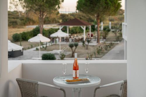 a bottle of champagne sitting on a table with two glasses at Naftilos Rosmarinus Apartments in Potokáki