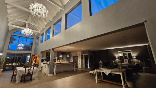 a large living room with tables and chairs and windows at Belle Vie Boutique Guesthouse in Pretoria