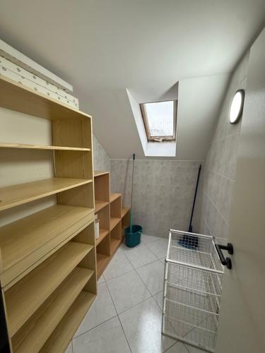 a walk in closet with wooden shelves and a skylight at Čisté a příjemné ubytování in Teplice