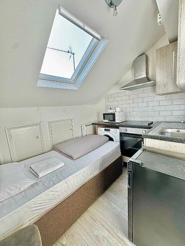 una piccola cucina con letto e finestra di Willesden Green Rooms a Londra