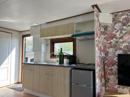 a kitchen with a bottle of wine on the counter at Bloemert aan de Maas in Aalst