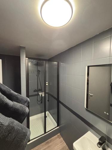 une salle de bain avec une douche avec un lavabo et un miroir dans l'établissement L'évasion popcorn, à Saint-Pierre-de-Plesguen