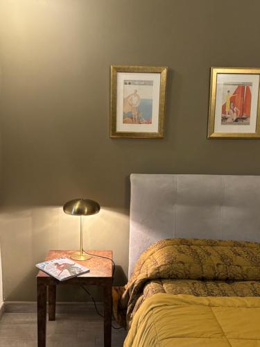 a bedroom with a bed and a table with a lamp at La Corte in Alba