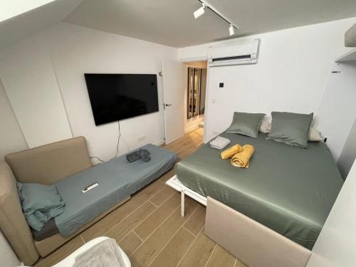 een slaapkamer met twee bedden en een flatscreen-tv bij PALM HOUSE apartment in Tarifa