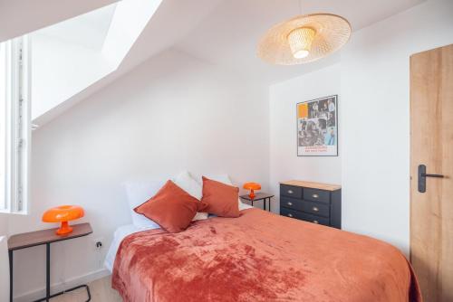 une chambre avec un lit avec des oreillers orange dans l'établissement Bright house Etaples center 4 to 6 people, à Étaples