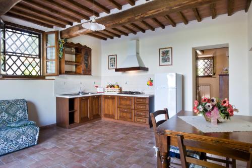 a kitchen with a table and a dining room at I Pianelli in Murlo