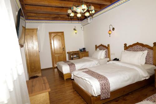 a bedroom with two beds and a chandelier at Istat Boutique Hotel in Bukhara