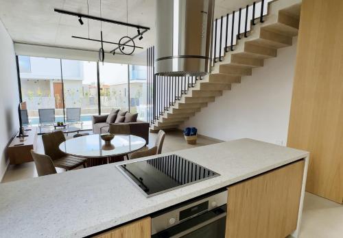 a kitchen and living room with a spiral staircase at Elysian Blue villa 2 in Paphos City