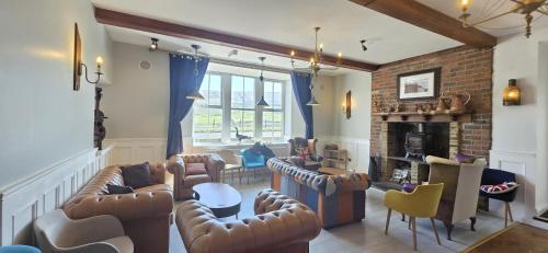 a living room with leather furniture and a fireplace at Turnpike by Maya Hotel & Restaurant in Rishworth