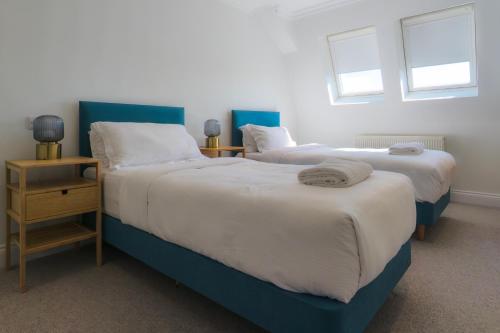 two beds sitting next to each other in a bedroom at Madison Hill - White Hill House 5 - 3 bedroom flat in London