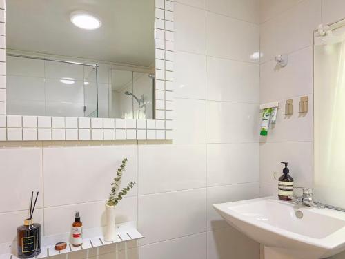 a white bathroom with a sink and a mirror at STAY ONDAM #3room #10guests in Seoul
