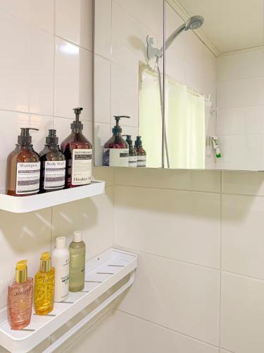 a bathroom with several bottles of oils on shelves at STAY ONDAM #3room #10guests in Seoul