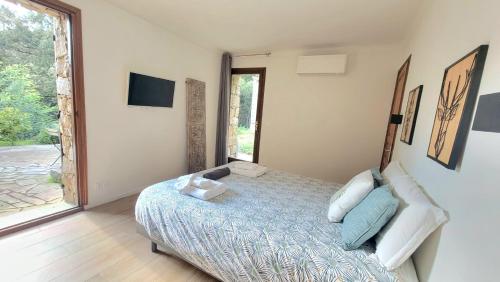 a bedroom with a bed and a large window at DOMAINE CARDU in Cardo-Torgia