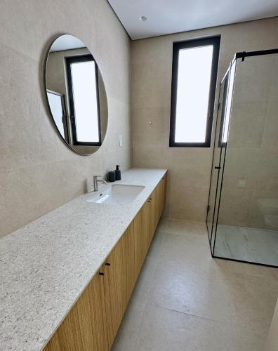 a bathroom with a sink and a mirror at Elysian Blue villa 2 in Paphos