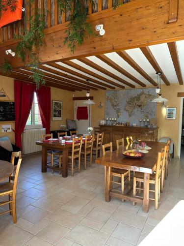 une salle à manger avec des tables et des chaises en bois dans l'établissement Chambres d'Hôtes Le Clos Tassin, à Colleville-sur-Mer