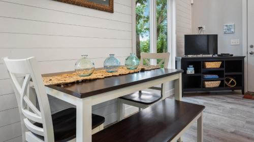 a dining room table with three glass vases on it at Cree Bay Cabin in Breezy Point