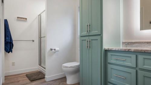 a bathroom with a green cabinet and a toilet at Cree Bay Cabin in Breezy Point