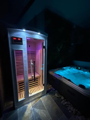 eine Whirlpool-Badewanne in der Nacht mit lila Licht in der Unterkunft L'instant in Cayeux-sur-Mer