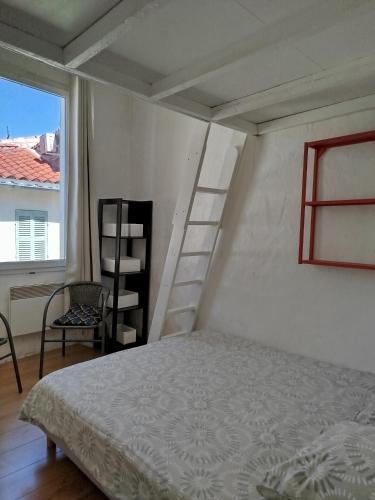 - une chambre avec un lit, une échelle et une chaise dans l'établissement Appartement lumineux, cinq personnes, centre historique de la Ciotat, à La Ciotat