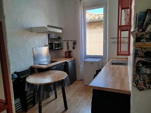 - une petite cuisine avec une table et un comptoir dans l'établissement Appartement lumineux, cinq personnes, centre historique de la Ciotat, à La Ciotat