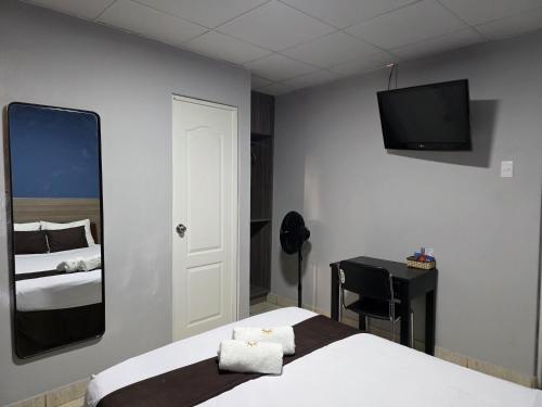 a bedroom with a bed and a mirror and a desk at Hotel Villa del Sol in Piura