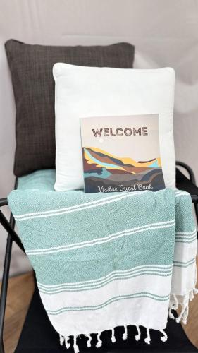 a pillow on a chair with a welcome towel on it at 2 domes in Glendale Utah Fantastic Stargazing in Glendale