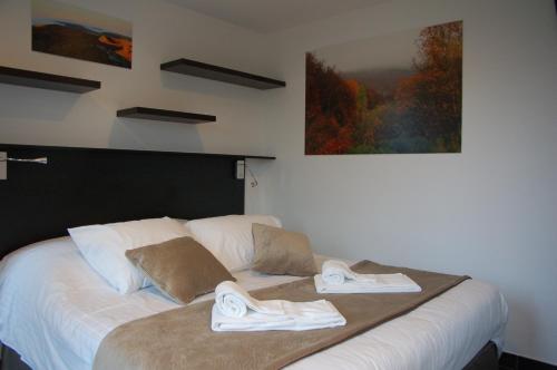 a bedroom with a bed with towels on it at Aux 500 Diables Eco Lodge - Hotel in Chambon-sur-Lac