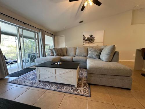 ein Wohnzimmer mit Sofa und Tisch in der Unterkunft Charming Villa with Private Pool 20 min to Disney! in Davenport