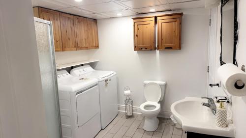 a bathroom with a washing machine and a sink at Private bedroom in Montréal